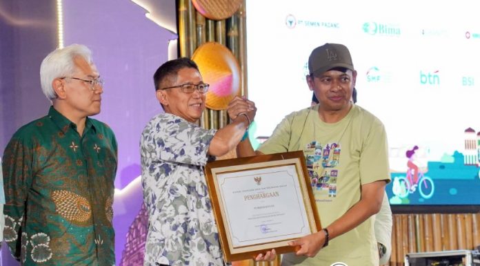 Direktur Jenderal Perumahan Kementerian PUPR, Iwan Suprijanto (kanan) menyerahkan penghargaan kepada mitra kerja bidang perumahan. (Foto: Kementerian PUPR) 