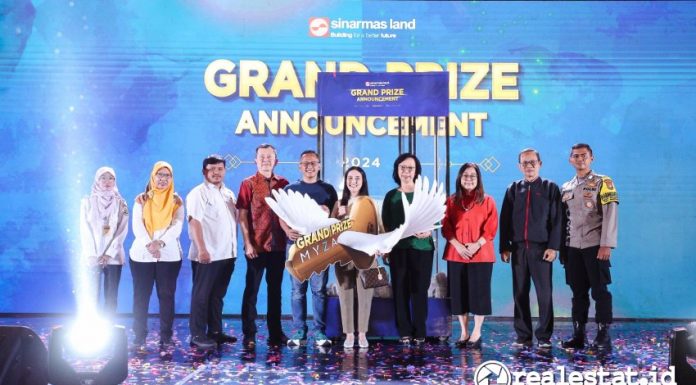 Jajaran Direksi Sinar Mas Land yang disaksikan perwakilan Kementerian Sosial RI, Dinas Sosial Kabupaten Tangerang/Banten, Notaris, dan Kepolisian memberikan hadiah utama berupa 1 unit Myza Flat-House BSD City kepada Ila Tartila, pemenang yang telah membeli rumah di Atherton, Kota Wisata pada program Infinite Living Periode I. Pengundian grand prize ini dilakukan pada Rabu (28/08/2024) lalu di Indonesia Convention Exhibition (ICE), BSD City.