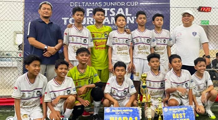 Happy Syarif, Community Relation Safety Security Manager Kota Deltamas menyerahkan Piala bagi Juara 1 Deltamas Junior Futsal Tournament 2024 kategori U13 yakni Tim Spd Academy Karawang. (Foto: Istimewa)