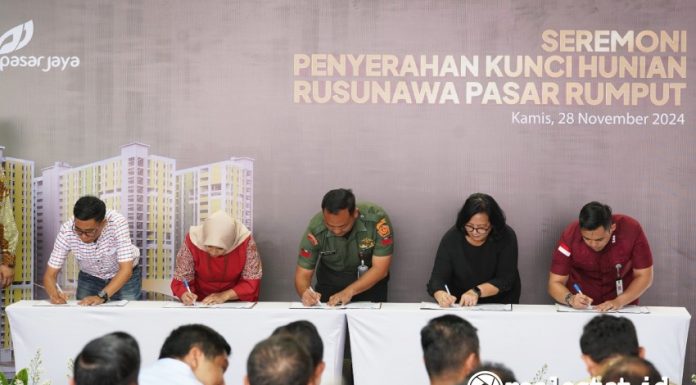 Perwakilan penghuni Rusun Pasar Rumput menandatangani dokumen saat acara serah terima unit, Kamis, 28 November 02024. (Foto: Kementerian PKP) 