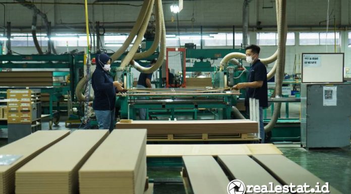 Pekerja di sektor industri furnitur sedang mengoperasikan mesin  untuk membuat pintu lemari. (Foto: RealEstat.id/Adhitya Putra)